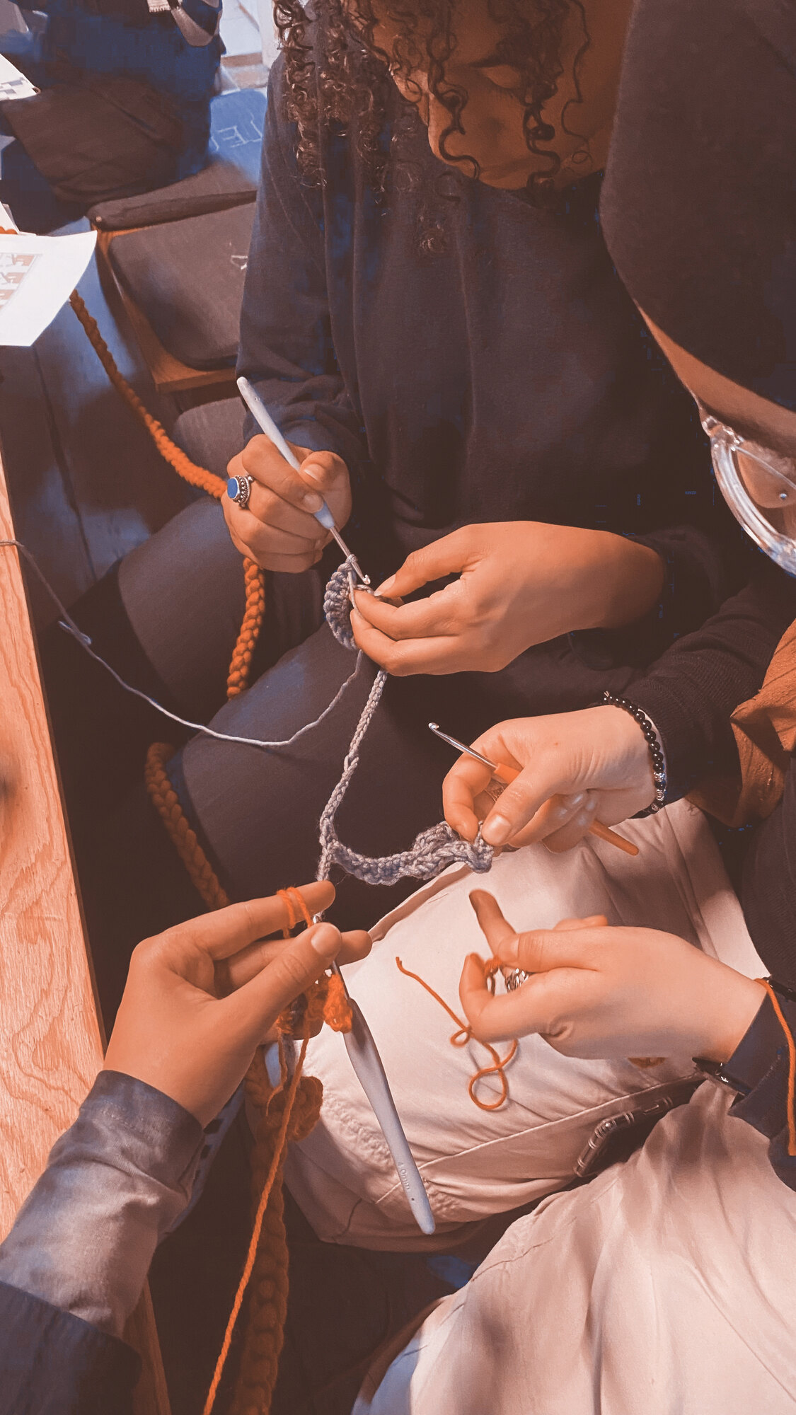 3 friends hooking themselves on a long chain and making some crochet blobs