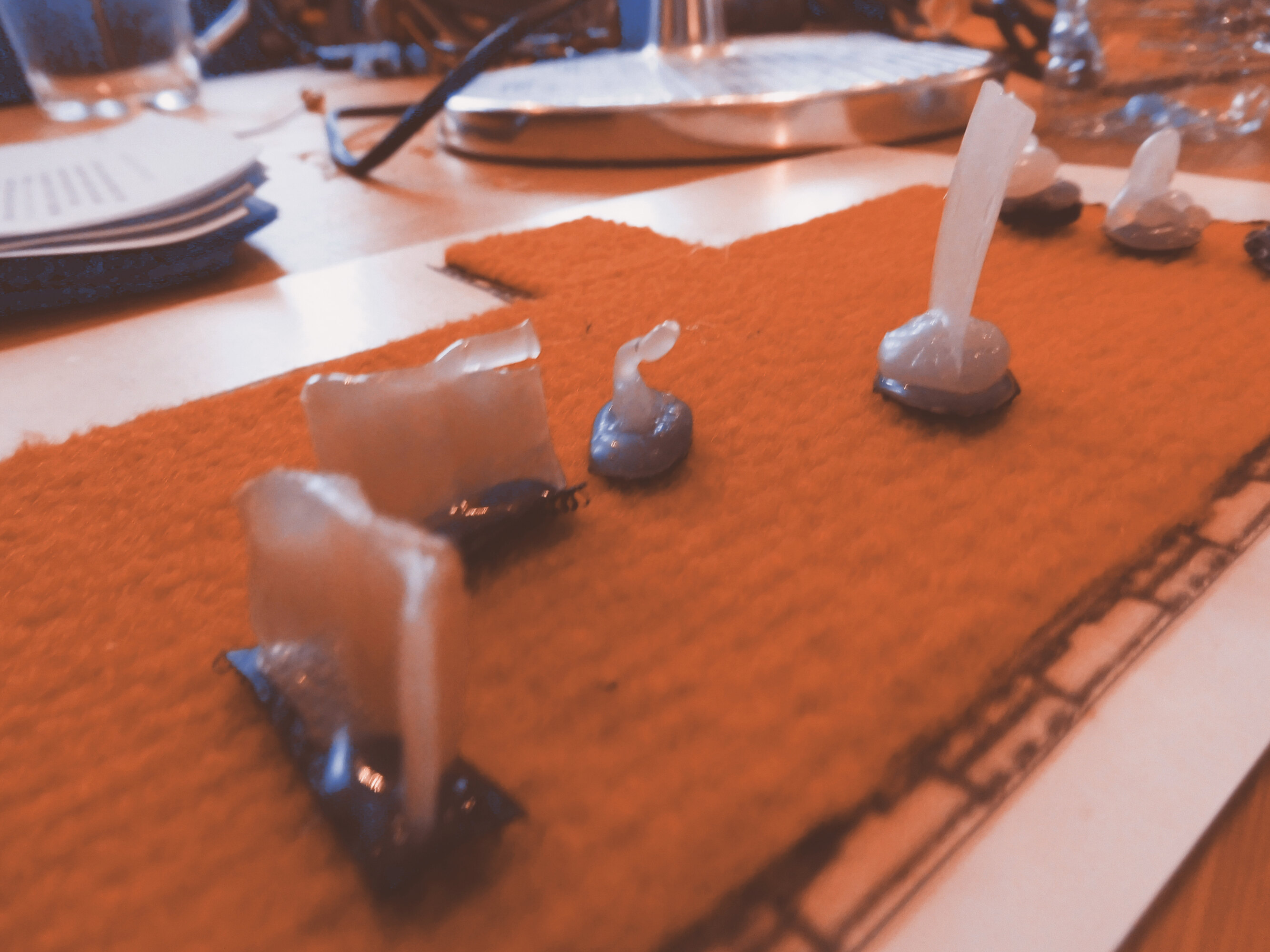 A close up of a map made in felt. The base of the map represents the floor of the room. Different shapes are attached to it. They are made in silicon and represents the removable walls where the paintings are hung, sculptures, armchairs and benches.