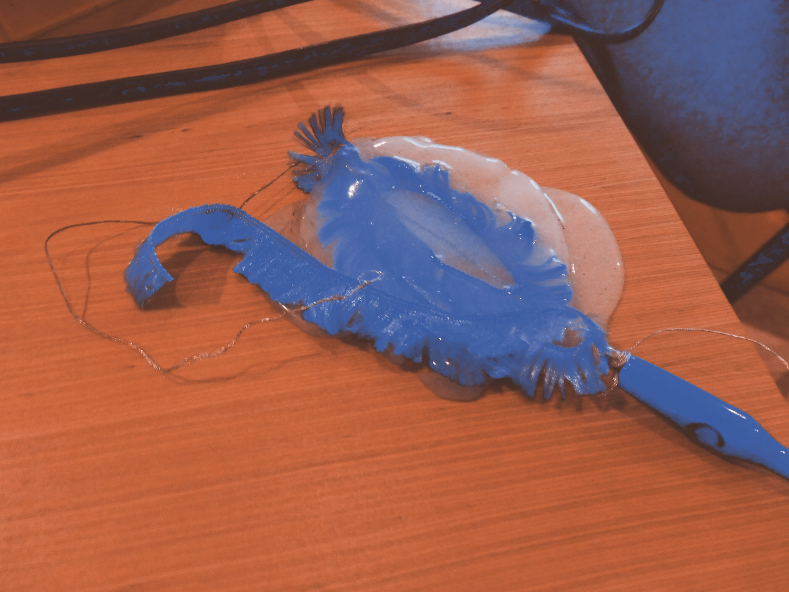 A close-up of one of the buttons present in the installation. The button has V shape and is made of a blue glittering fabric and silicon.